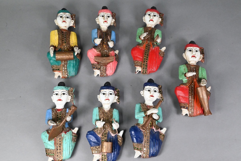 A set of seven vintage polychrome Burmese temple musician wall plaques, carved hardwood with