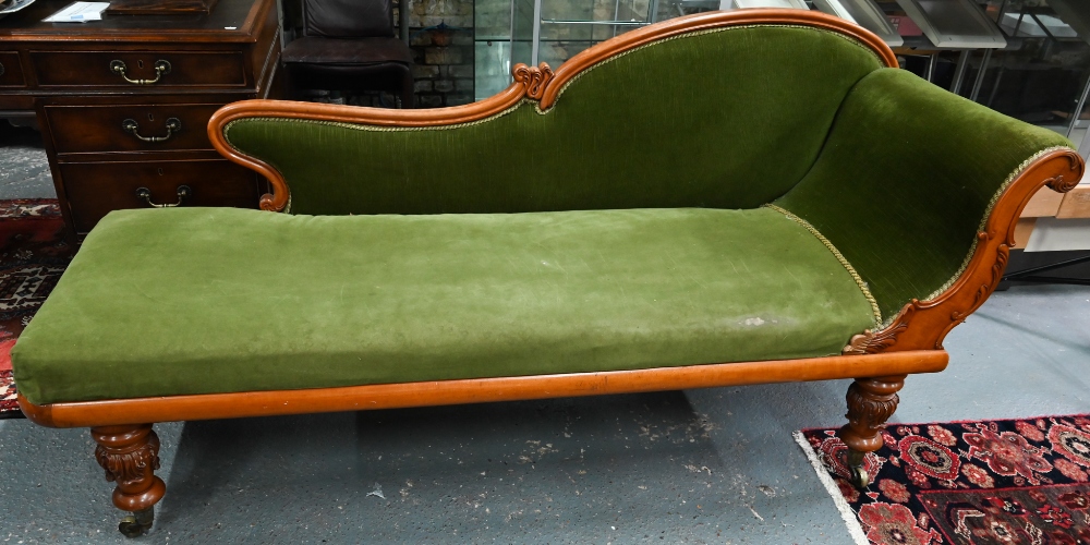 A late Victorian walnut framed single scroll end chaise, upholstered in green dralon, raised on