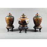 A pair of late 19th or early 20th century Japanese cloisonne ovoid vases with domed covers and