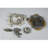 A chunky silver curb bracelet with ten various charms attached including gramophone, tankard,