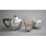 Victorian silver three-piece bachelor tea service of half-fluted oblong form, on later plated bun