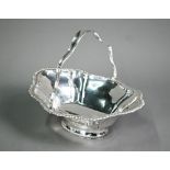 An Edwardian silver basket with swing loop handle and gadrooned rim , on raised oval foot, James