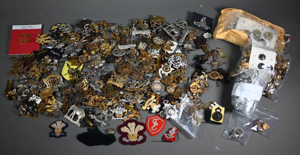 A quantity of assorted military cap badges and insignia, mostly British and to/with assorted tunic