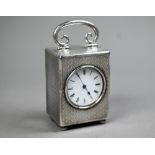 A late Victorian silver boudoir clock with hinged top handle, engine-turned decoration and bun feet;