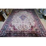 A fine Persian handmade Kashan carpet, the floral vine design on cream ground centred by a blue