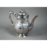 A George III silver coffee pot with embossed decoration and ivory insulators and finial pillar,