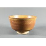 A 20th century Japanese pottery Fujiwa-yaki honey glazed tea bowl (chawan) on triangular incised