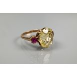 An 18ct yellow gold ring set with central pale yellow stone with ruby to each side, size Q