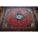 An Indo-Persian Kashan carpet, the red ground centred with a blue ground floral medallion Good pile,