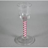 A Georgian cordial glass cut with intertwined foliated guilloches, on red/white opaque triple-