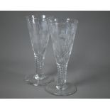 An antique pair of large conical glass goblets, wheel-etched with vine decoration on spiral-reeded