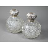 A pair of Edwardian hobnail-cut globular cologne bottles, the hinged silver bun covers with embossed