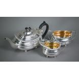 A heavy quality silver three-piece tea service in the Regency manner, of compressed oblong form with