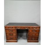 An antique mahogany twin pedestal desk, the leathercloth inset top over an arrangement of nine