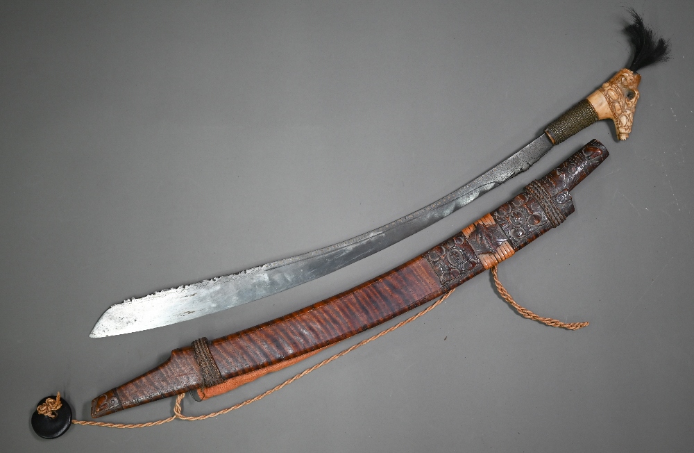 A Dyak sword, Mandu, the blade with brass inlay and pierced decoration to edge, the carved bone hilt