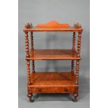 A Victorian walnut three tier what-not with barley twist supports, over a base drawer, on brass