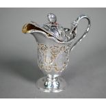 An unusual Victorian silver cream jug, the hinged cover with melon finial, the body ornately pierced