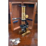An antique lacquered brass small microscope, 24 cm, in mahogany case