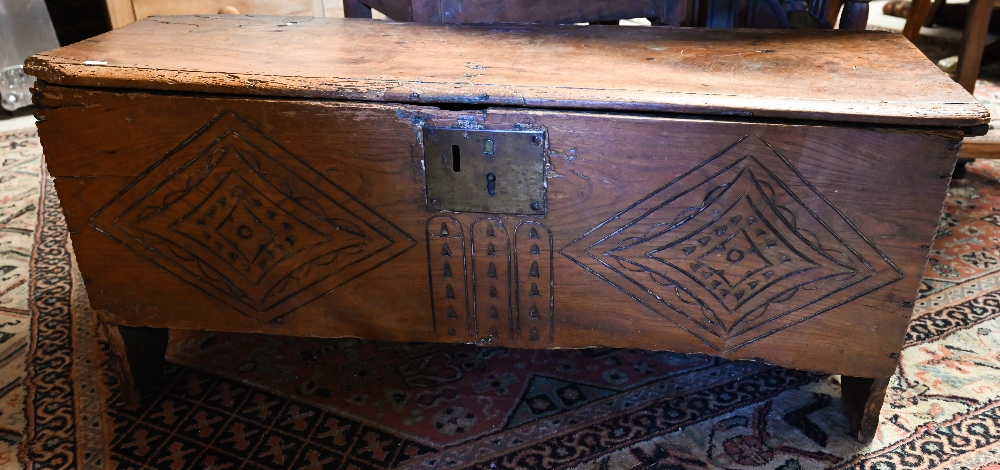 An antique elm six-plank coffer with carved front panel 102c m w x 35 cm d x 40 cm h