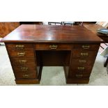 An old mahogany partners style kneehole desk, one side with eleven drawers opposing three cupboards,