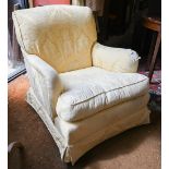 A Howard style armchair on mahogany legs and brass casters, pale yellow damask upholstery
