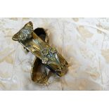 A pair of brass wall-mounted curtain tie-backs featuring stylised flower motifs to/w two pale gold