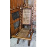 A Victorian walnut and cane panelled folding campaign chair