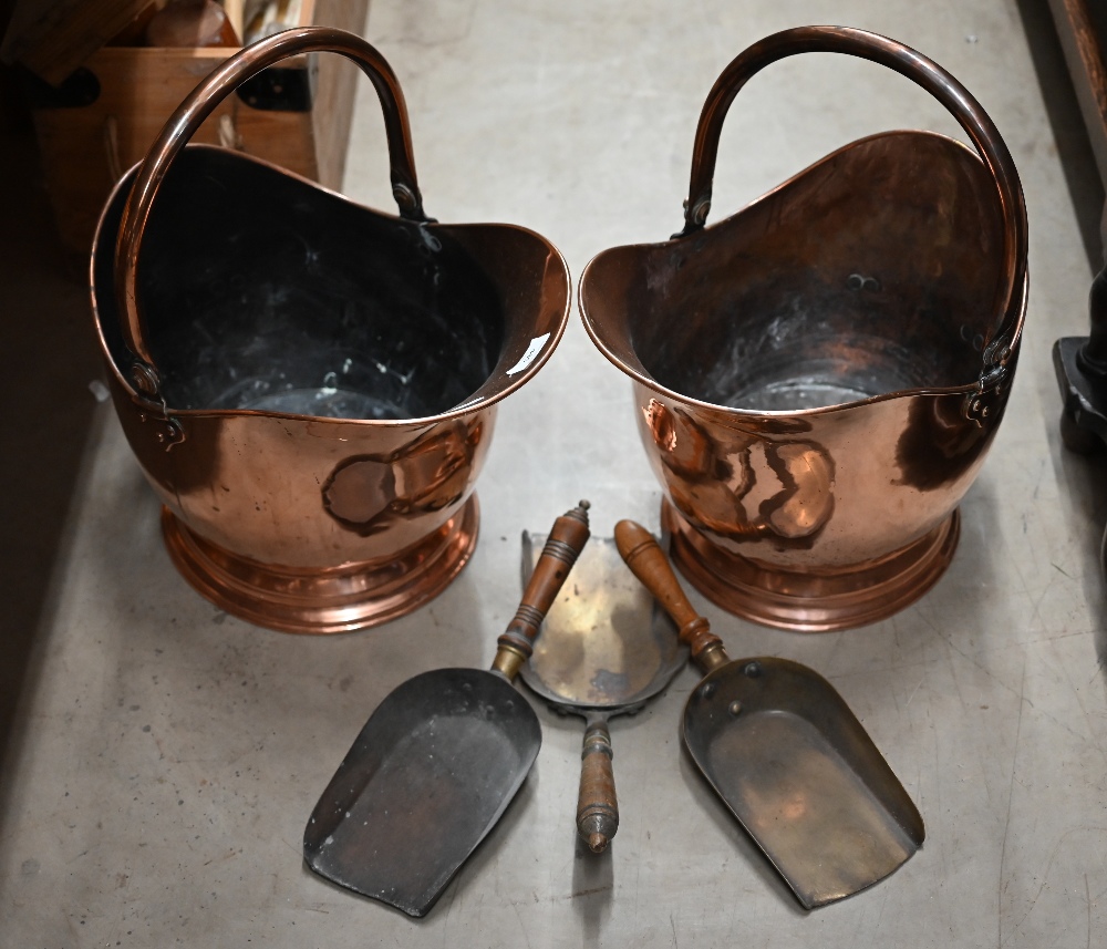 A pair of antique copper helmet scuttles with swing handles, c/w three various shovels