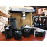 A Canon AE-1 SLR camera with Canon.FD 50mm 1:1,8 lens, FD 135 mm 1:3,5 lens, Sigma APO zoom 1:4.5-
