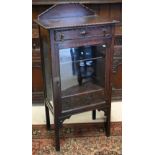 An early 20th century carved oak display cabinet with drawer over glazed door, 62 cm wide x 40 cm