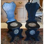 A pair of George II style ebonised and faux marble panelled hall chairs (2)
