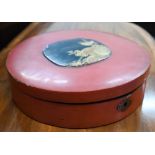 A Japanese red lacquer circular box with hinged cover and central black and gilt Kachio Ga panel, 28