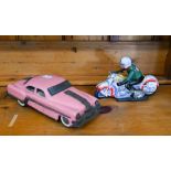 A Chinese tinplate clockwork racing motorcyclist, 12 x 18 cm to/w a Minster pink clockwork car (2)