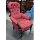 A Victorian mahogany framed button back armchair on turned legs with brass casters