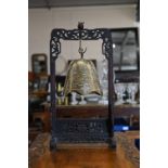 Chinese brass bell on carved and pierced stand, 49 cm high