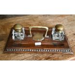Military interest - A brass mounted oak ink stand, with square glass bottles and shield engraved '