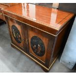 A modern hardwood side cabinet with two panelled japanned doors enclosing fitted interior and gilded