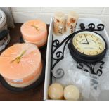 Two multi-wick candles on metal stands, two other pairs of candles and a double-faced clock