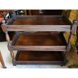 An antique mahogany three tier dumb waiter - later converted to a trolley on rubberised spoke