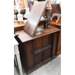 An antique treadle Singer sewing machine in oak cabinet with panelled doors