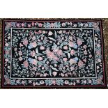 A traditional needlepoint rug, floral design on black ground, 183 x 123 cm