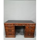 An antique mahogany twin pedestal desk, the leathercloth inset top over an arrangement of nine