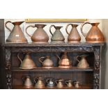 A collection of fifteen various antique copper conical measures, gallon to gill
