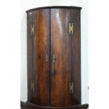 An 18th century oak barrel front hanging corner cupboard c/w key, 92 cm high