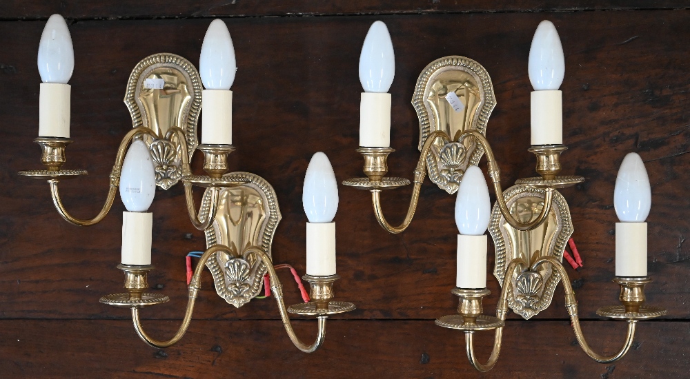 Four brass twin-branch wall sconces with beaded wall plates