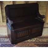 A dark oak metamorphic monks bench with carved top