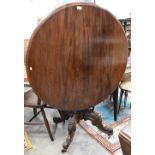 A Victorian mahogany circular tilt-top table with floral and foliate carved base with baluster