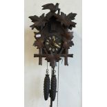 A traditional Continental Black Forest style cuckoo clock c/w pendulum and two pine cone weights,