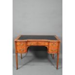 A late 19th century cross-banded satinwood desk, the top with leather surface over five drawers,