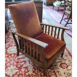 An early 20th century Arts & Crafts reclining open armchair with integrated fold-away foot stool